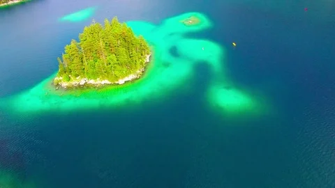 Drone flight over mountain lake Eibsee beneath Zugspitze peak. Video stock 84837670