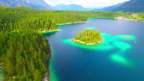 Drone flight over mountain lake Eibsee beneath Zugspitze peak. Video stock 84837996