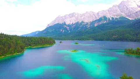 Drone flight over mountain lake Eibsee beneath Zugspitze peak. Video stock 84838470