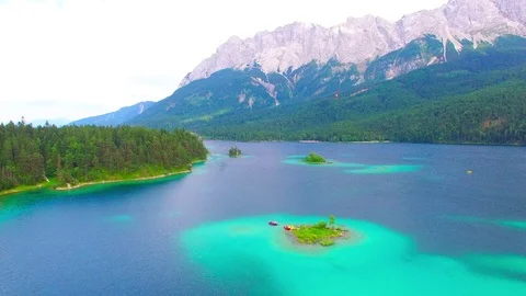 Drone flight over mountain lake Eibsee beneath Zugspitze peak. Video stock 84839158