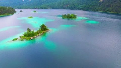 Drone flight over mountain lake Eibsee beneath Zugspitze peak. Video stock 84839215