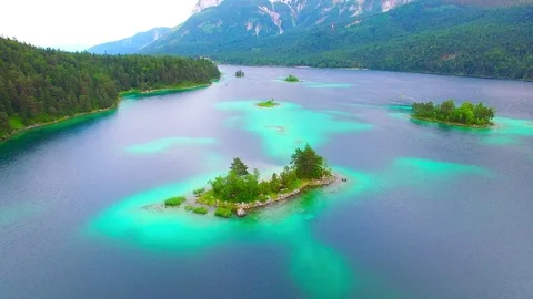 Drone flight over mountain lake Eibsee beneath Zugspitze peak. Video stock 84839373