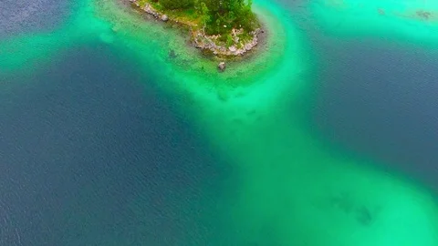 Drone flight over mountain lake Eibsee beneath Zugspitze peak. Video stock 84839520