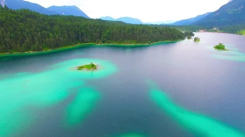 Drone flight over mountain lake Eibsee beneath Zugspitze peak. Video stock 84840891