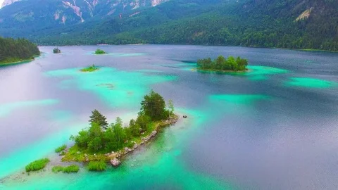 Drone flight over mountain lake Eibsee beneath Zugspitze peak. Video stock 84841632