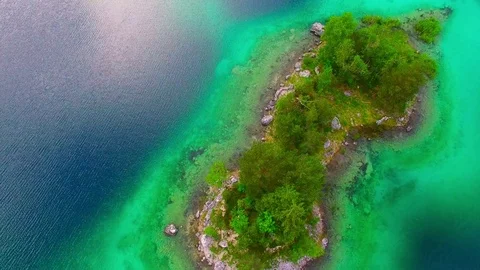 Drone flight over mountain lake Eibsee beneath Zugspitze peak. Video stock 84841896