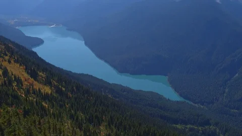 Drone Flight over Mountain Side and Glacier Lake Pan Up to Snowy Mountain Range 動画素材 82634132