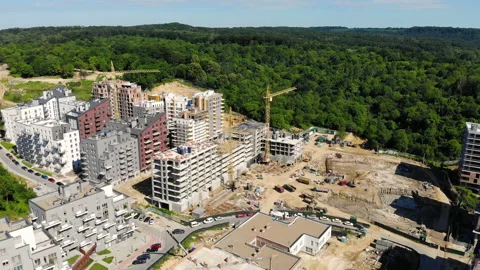 Drone flight over a new building under construction near a forest Stock Footage 139965506