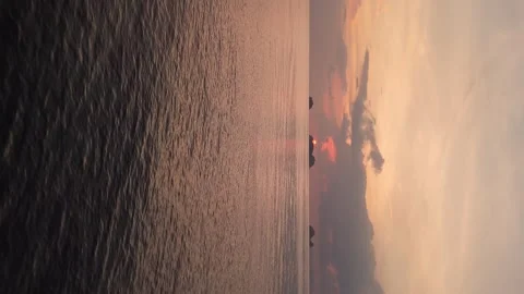Drone flight over ocean, against sunset mountains, illustrates technology impact Stock Footage 270417870