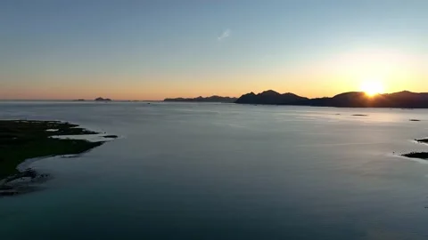 Drone flight over the ocean with sunset sky and mountains on the horizon in 4k Stock Footage 222001478