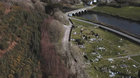 Drone flight over the old catalic cemetery near the river with a bridge Stock Footage 234111515