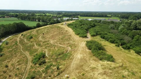 A drone flight over an old waste dump, completely taken over by trees and plants Video stock 277486300