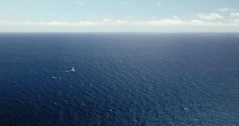 Drone Flight over Open Sea with Waves and Distant Sailboat, Canary Islands Stock Footage 316670290