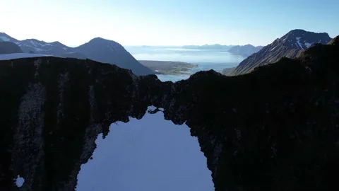 Drone flight over a pass in the mountains into the fjord in 4k Stock Footage 222948201