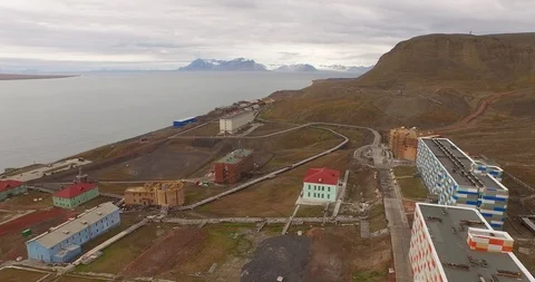 Drone flight over the pipe stretching by the ground along the settlement of Stock-Footage 121812984