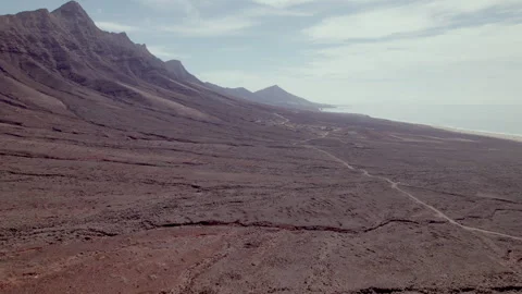 Drone flight over Playa de Cofete beach and surrounding desert landscape Stock Footage 309858863