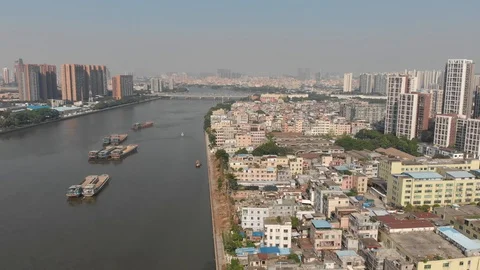 Drone flight over a poor area in China. A dirty navigable river Stock Footage 118213336