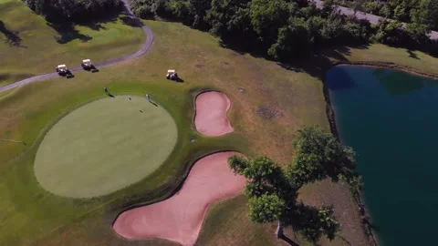 Drone flight over putting green with pond, 4k Stock Footage 135950553