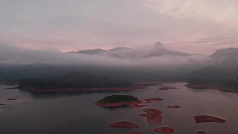 Drone flight over a quiet reservoir with fog and forested hills in the Stock Footage 327064977