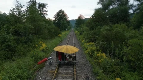 Drone flight over a railway construction cart on rails with yellow umbrella Stock Footage 249265445