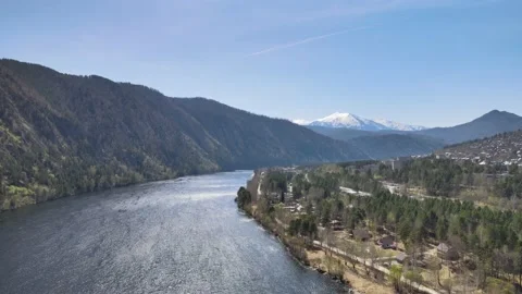 Drone flight over the river and on the shore overlooking the snowy mountain Video stock 199041005