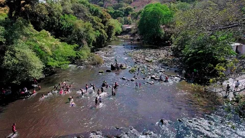 Drone flight over a river full of people in the middle of a forest Stock Footage 101314758