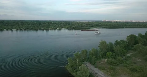 Drone flight over the river overlooking the tug barge and sailboat in the Stock Footage 135798656