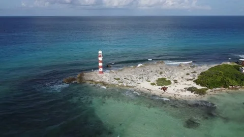 Drone flight over rocks towards red and white lighthouse and caribbean sea Stock-Footage 201377938