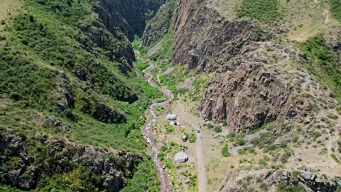 Drone flight over a rocky gorge. Yurts with resting tourists, natural landscape Stock Footage 274299623