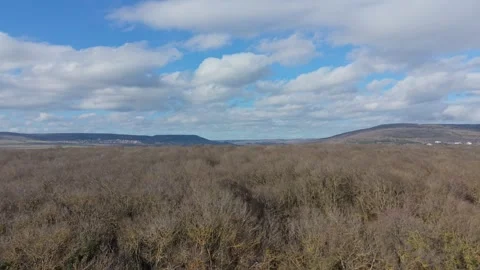 Drone flight over rolling hills under blue sky with clouds Stock Footage 328572147