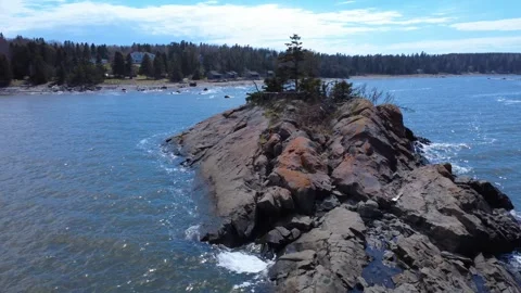 Drone flight over a rugged Paleozoic rock ridge near Pointe-Mitis Lighthouse Stock Footage 337323040