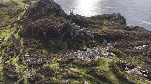 Drone flight over rugged sea cliffs toward the Atlantic Ocean at sunset Stock Footage 342711482