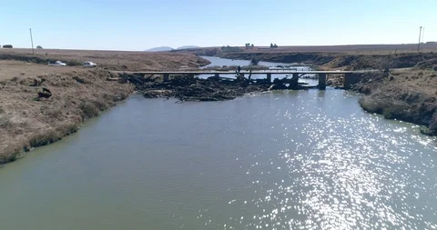 Drone flight over rural bridge backed up by dead trees from last years floods 스톡 동영상 93486958