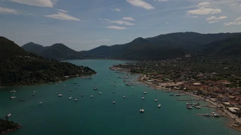 Drone Flight Over Scenic Bay with Sailboats, Coastal Town and Mountain Landscape Stock Footage 336514200