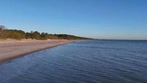 Drone flight over serene seaside landscape showcasing clear blue skies Stock Footage 308695041