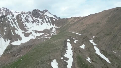 Drone flight over snowy alpine slopes on the ascent to Peak Pamyati, Kazakhstan Stock Footage 340423357