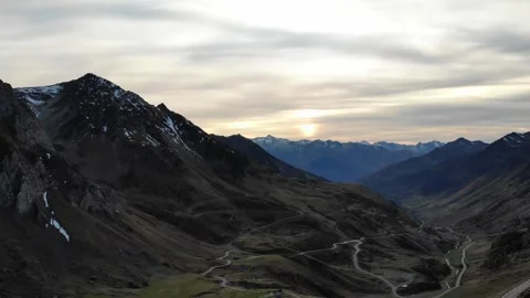 Drone flight over snowy mountain with winding roads in France Stock Footage 331710590