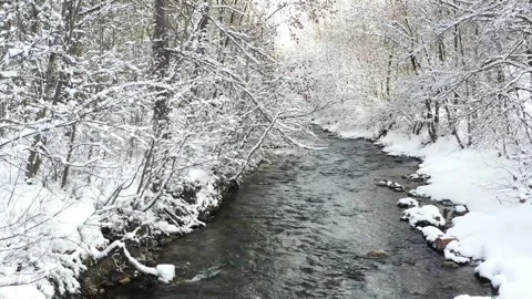 Drone flight over snowy river in peaceful winter landscape Stock Footage 327647162
