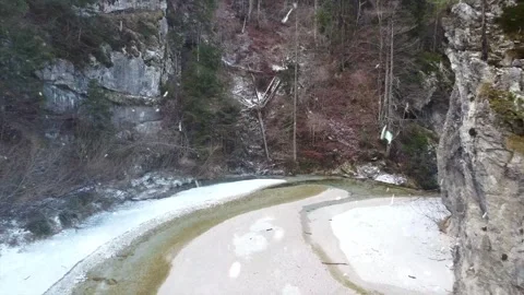 Drone Flight Over Snowy River Valley at Sunset with Falling Snow Video stock 330278990