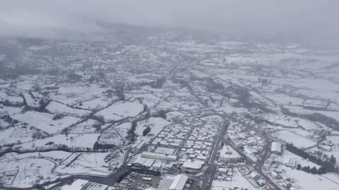 Drone Flight Over a Snowy Town on an Overcast Day Stock Footage 325575315