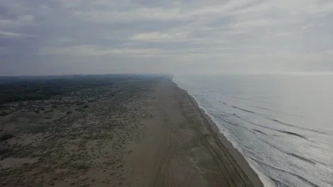 Drone flight over the tracks on the beach towards the foggy horizon at sunset. Stock Footage 247698625