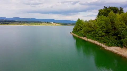 Drone flight over tuscan lake with changing weather Stock Footage 320842532