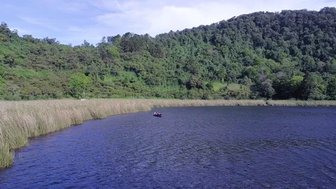 Drone flight over a volcanic lagoon and a group of tourist traveling Stock Footage 100776296