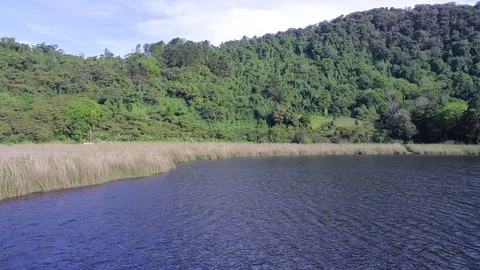 Drone flight over a volcanic lagoon and a group of tourist Stock Footage 100782590