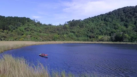 Drone flight over a volcanic lagoon and a group of tourist Stock Footage 100788118
