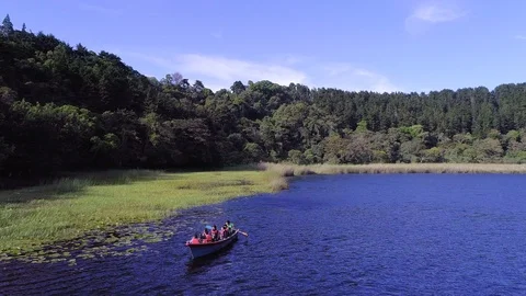 Drone flight over a volcanic lagoon and a group of tourist Stock Footage 100794453