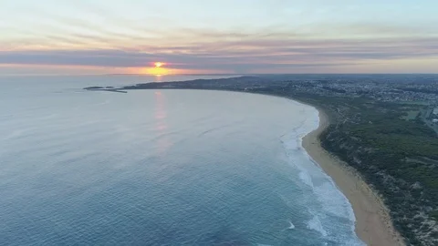 Drone flight over Warrnambool ocean coastline towards the sun at scenic sunse Stock Footage 107485821