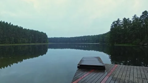 A drone flight over a wooden dock sits on the edge of a lake Stock Footage 320564446