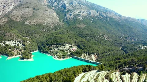 Drone flight overlooking azure mountain lake, farmland and dam Stock Footage 302914835