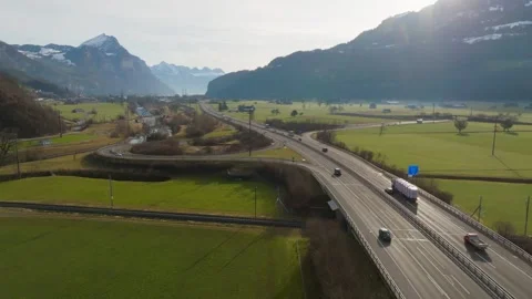 Drone flight parallel to a highway running through a green mountain valley Video stock 321503921